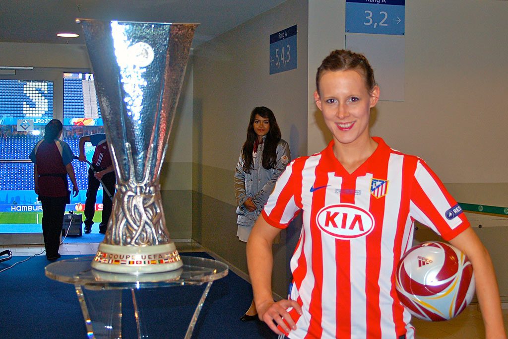 Fußball-Akrobatin Miriam Willems neben dem Pokal der UEFA Europa League