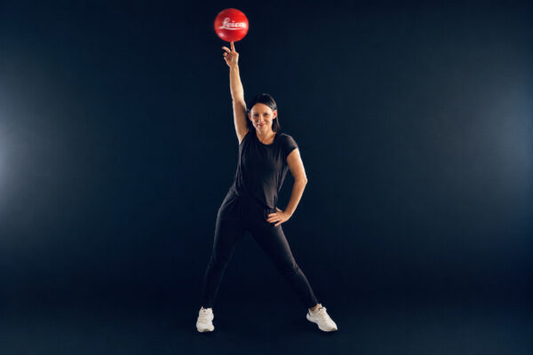 Fußballkünstlerin Miriam Willems balanciert einen Leica-Fußball auf dem Finger beim Launch der Leica SL3-P im Leica Flagship Store Frankfurt.